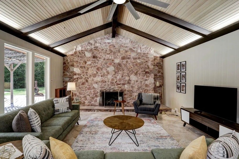 A sala de estar conta com uma lareira de pedra — Foto: Divulgação/Sotheby’s International Realty