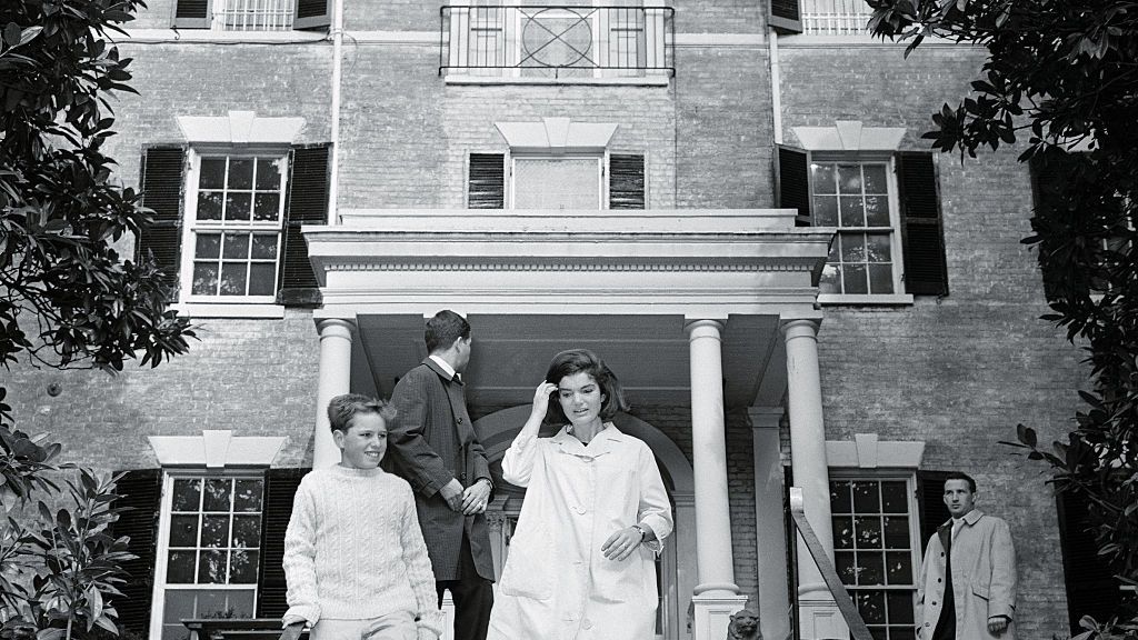A ex-primeira-dama deixando seu endereço em Georgetown em 1964 com seu sobrinho Joe Kennedy.